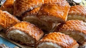 Armenian gata pastry cut into pieces with golden flaky crust and sweet buttery filling on a serving tray